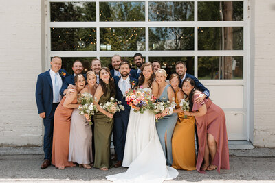 Bridal party smiling looking at camera outside of Wild Carrot in Missouri