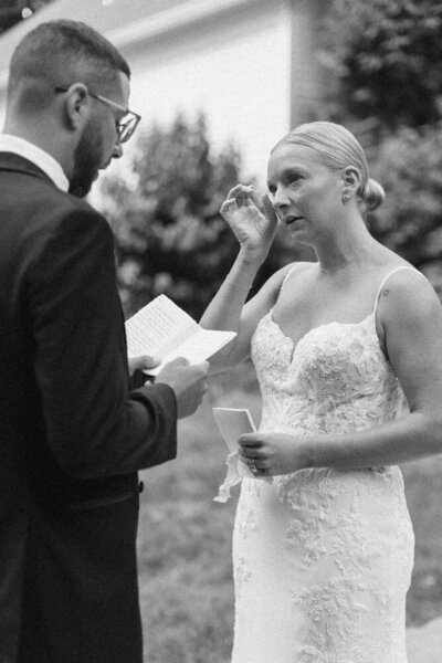 bride and groom sharing vows while bride is crying