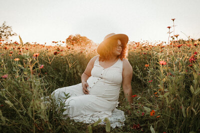 Expecting mother enjoying a peaceful moment in a flower farm, photographed near Charlotte, NC.