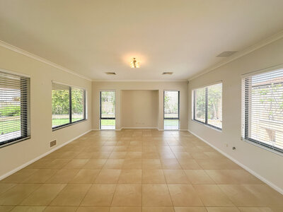 Living area in Mandurah home with cream walls and beige tiles.