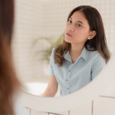 a girl looking in the mirror