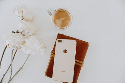 white Iphone with coffee and white flowers