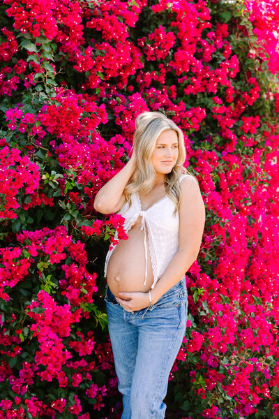 Expecting mom surrounded by bouganvillea flowers