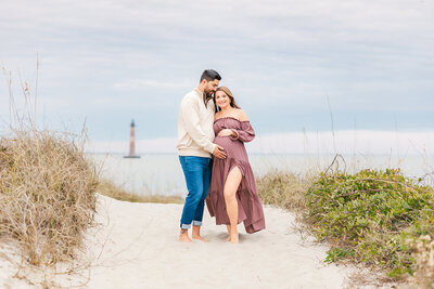 mom and dad by the lighthouse for maternity session