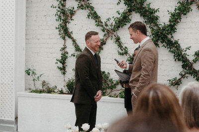 Dave smiling at Chris during their rooftop vow exchange at Quirk Hotel Richmond.