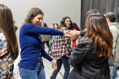two women laughing and dancing together