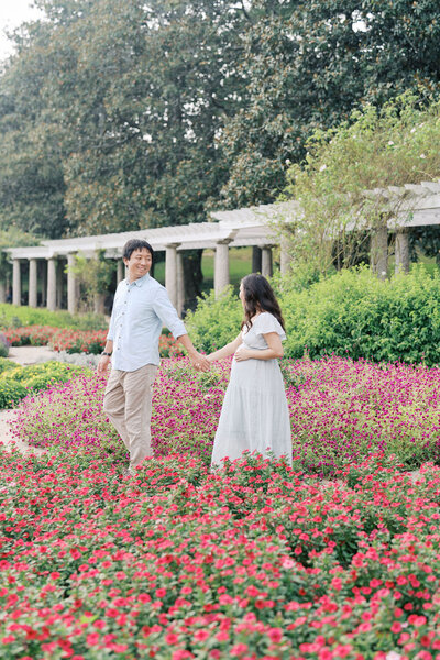 Richmond Family Photographer | Film Photo of a pregnant mother sitting on a hand-painted watercolor backdrop in a beige dress, holding her belly and looking in a mirror by Jacqueline Aimee Portraits