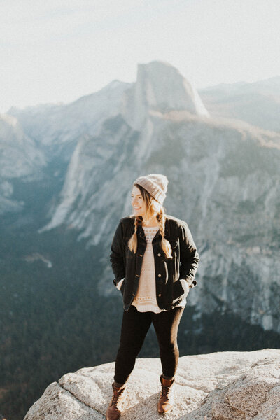 woman standing on edge near mountain landscape