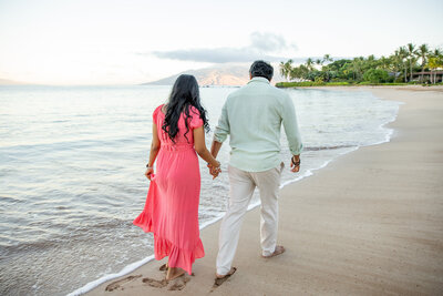 Hawaii Engagement Photographer captures man and woman holding hands while walking on beach