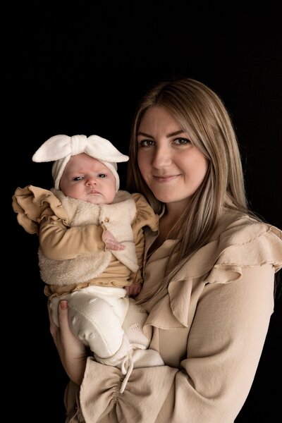 Baby portret met moeder en zwarte achtergrond.