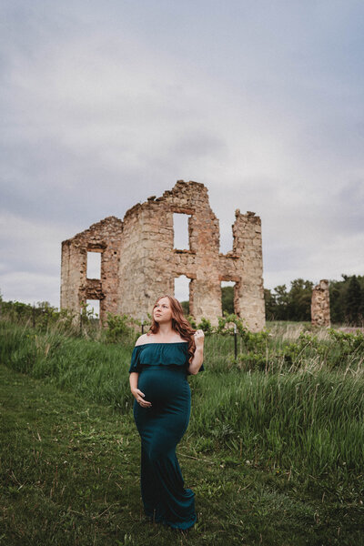 pregnant lady wearing black dress with tattoos on stomach in Rio, WI portrait studio