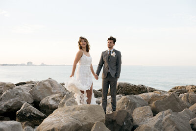 Bride and groom standing on rocks of upham beach in St Petersburg Florida