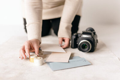Photographer placing wedding details for a flatlay photo