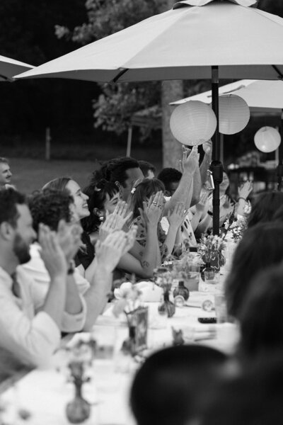 Black and white image of bride and groom cutting cake