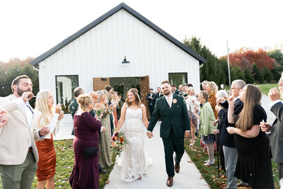 candid moment of bride smiling at her parents during grand exit from wedding ceremony at The Wellspring in Wooster, Ohio