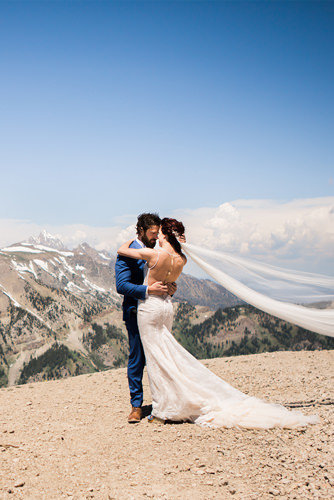 A bride and groom laugh together on a beach on Camano Island after their elopement