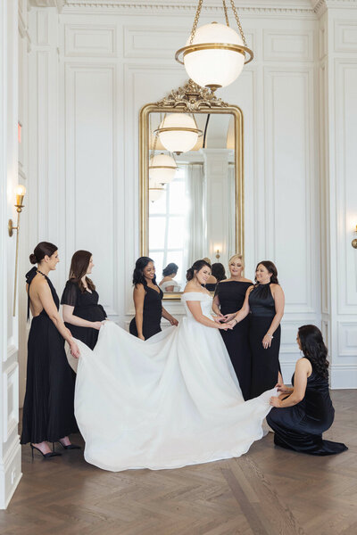 Portrait of the bride with six bridesmaids in black dresses at a black-tie wedding at The Adolphus.