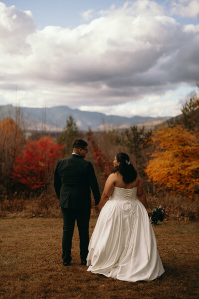 bride and groom looking out over Vermont hillside in fall