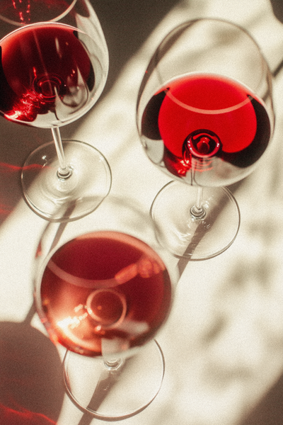 ammithre_light_shining_through_burgundy_rose_and_white_wine_gla_ca1e5fc4-09ad-4a91-a25c-cf91bec18bb3