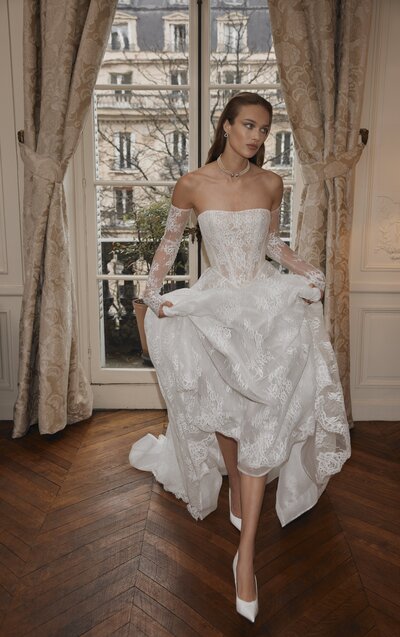 black and white image bride wearing strapless satin wedding dress with long train