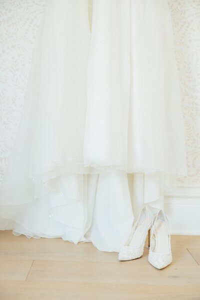 The brides dress draped over her shoes.