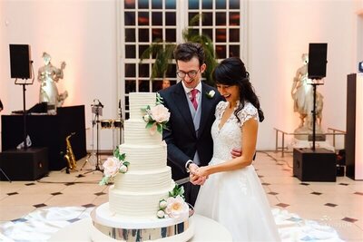 A couple cutting their wedding cake in the Orangery at Kew Gardens