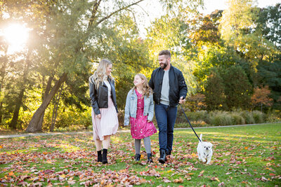 family with girl and small white dog