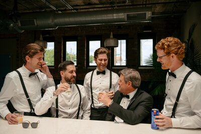 groom enjoying a drink with his groomsmen
