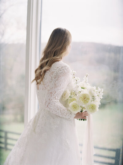 Bride in White Dress Looking Out the Window