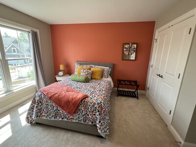 Colorful bedroom with a bold coral accent wall