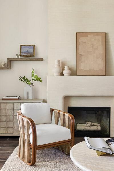 Neutral U-Shaped Couch, Paired Perfectly with a Sleek Black Circular Coffee Table, Gold Accents, Stone Pots, and Lush Greenery