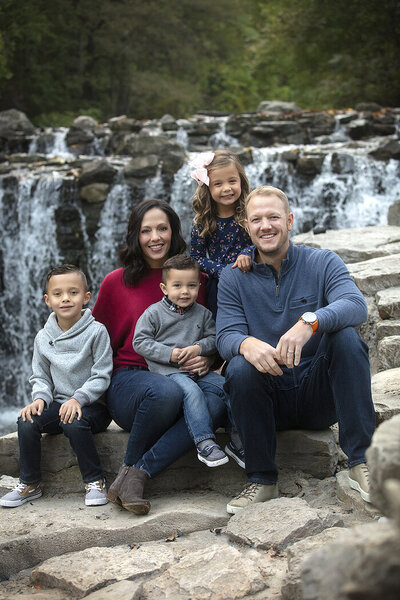 Family photos sitting in front of waterfall at prairie creek park