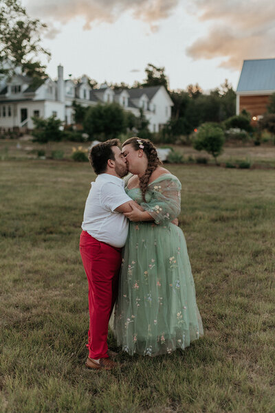 couple kissing on lawn at sunset