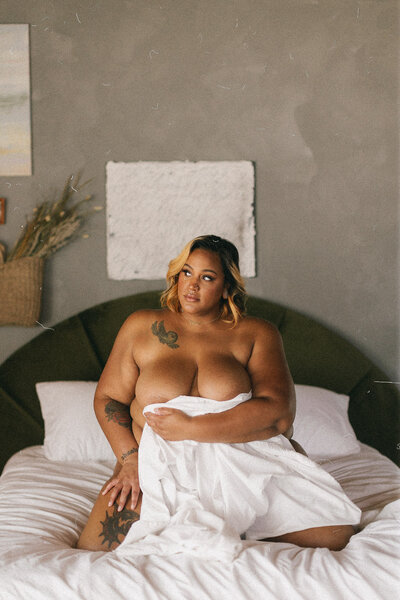 Nude Good Bodies client holding a sheet in front of their body