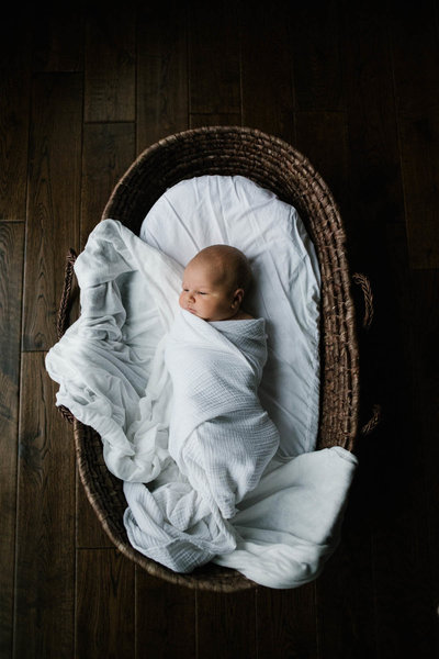 New Lenox newborn photographer Laurie Baker captures a baby in a Moses basket