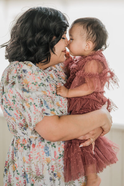 Mom and daughter in beautiful dresses give eskimo kisses during porch pictures by Cassey Golden Photography in San Antonio.
