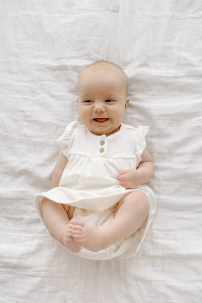 Baby laying on back and smiling up during photos with  Indianapolis newborn and family photographer Capturing Simplicity Photography