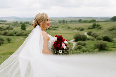 A bride poses with her bouquet at the Sirocco Golf Club in Calgary, Alberta