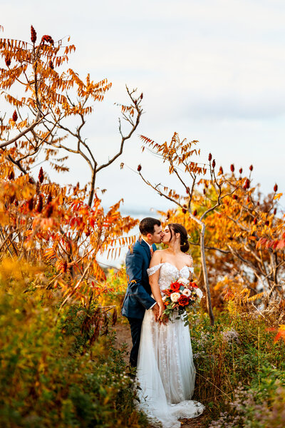 Wedding portrait of a couple in the Maine woods with green trees with heads together