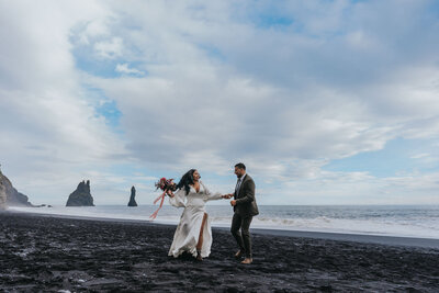 Husband and wife dance during their Iceland Elopement on the Black Sand Beach