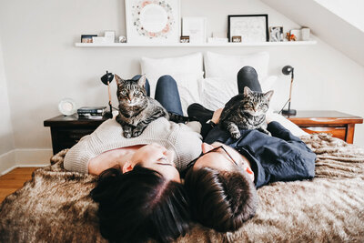 Cute couple handing out with their cats at home during engagement photo session