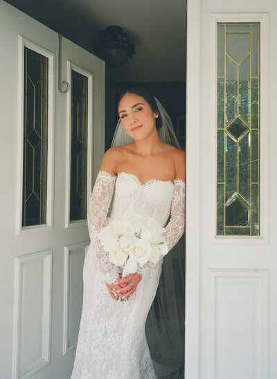 Flatlay of white floral bouquet, coupes, and wedding stationery