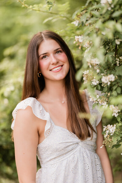 Group of girls in graduation caps and gowns on a football field.