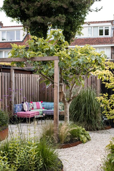 Een lichte en moderne tuin met zonovergoten hoekjes, ontworpen voor ontspanning en sfeer.