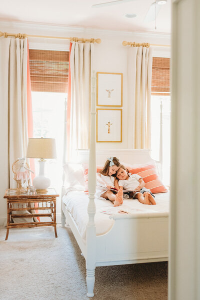 brother and sister reading on a bed