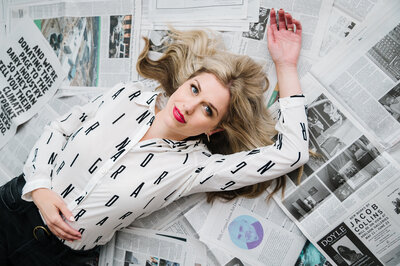 Sarah Klongerbo holding up a magazine page that she lit on fire