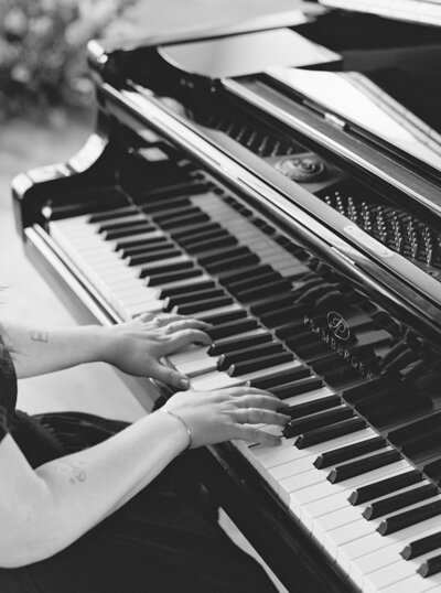 Black and white photo of Mikaela Kahn's hands playing the piano