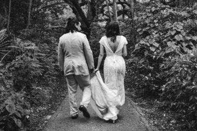 Black and white portrait of Bride and Groom walking in the woods at their New England Elopement