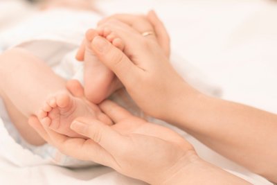 mothers-hands-gently-hold-the-feet-of-a-newborn-baby-in-the-palms-adoption-arms-arrival-attention_t20_E4lyY4