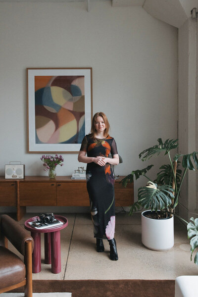 Documentary wedding photographer, Eryndae, standing in an artful office space
